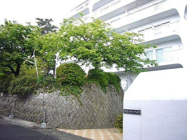 【外観】熱海スカイハイツの玄関口。木々の緑とマンションの白さが一層際立ちます。